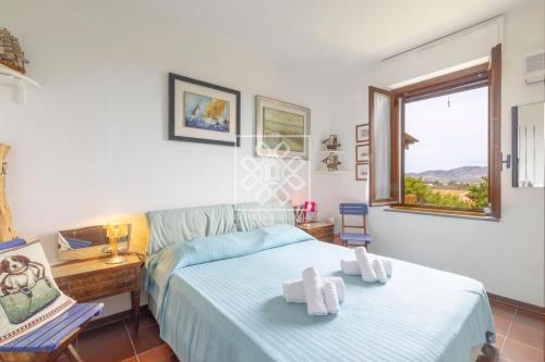 1 dormitorio con 1 cama con 2 toallas en Casa Maria Grazia, en Stintino