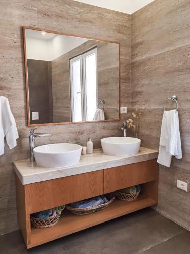 a bathroom with two sinks and a large mirror at Joni & Joy Center Apartment in Berat