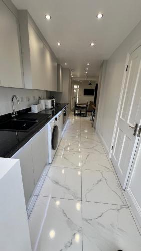 チャタムにあるSan Pedro Lodge Chathamの大理石の床と洗濯機と乾燥機を備えたキッチン