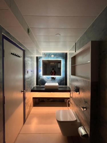bagno con servizi igienici e TV a parete di Spruce Hill Hotel & Restro a Nainital