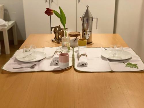 een houten tafel met twee borden en glazen erop bij Old Town Moschetti 20 in Corato