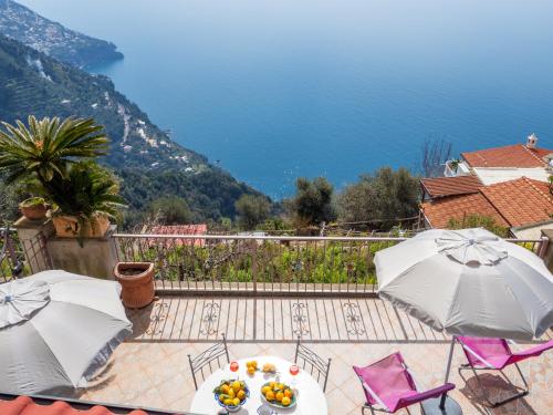 Un patio con mesas y sombrillas y vista al mar. en Villa Lavinia Nocelle, en Positano