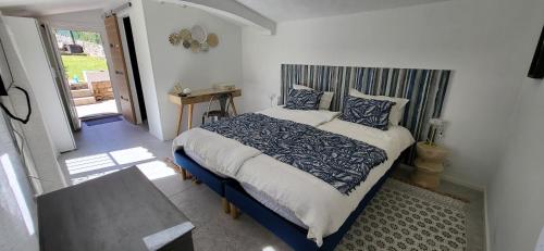 a bedroom with a bed with blue and white pillows at Les Pierres de Cézaire in Saint-Cézaire-sur-Siagne