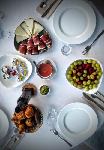 Una mesa blanca con platos de comida encima. en Corzo Hotel, en Cercedilla