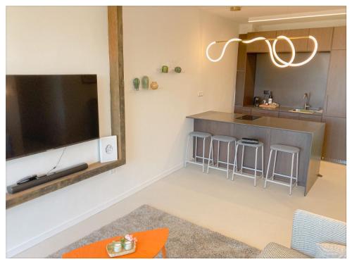 sala de estar con cocina y TV grande en Malaya suite - Neot Golf en Caesarea