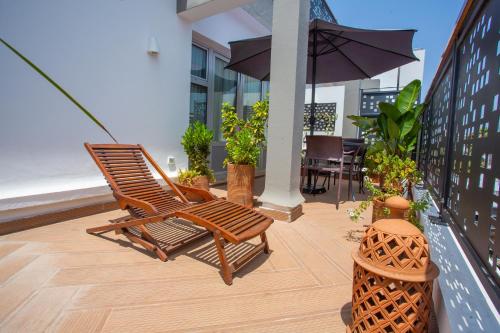 a pair of chairs and an umbrella on a balcony at Le Pietri Urban Hotel in Rabat