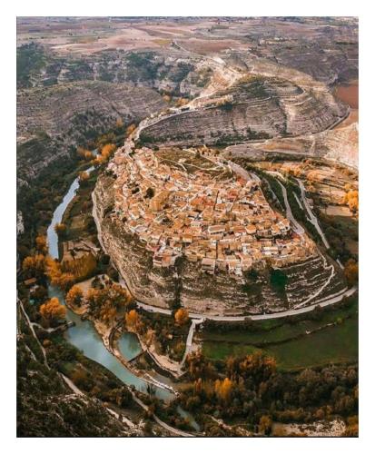 an aerial view of a city with a river at Casa Rural El Abejorro in Alcalá del Júcar