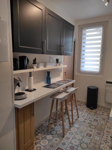 - une cuisine avec un comptoir et des tabourets dans l'établissement Charmant T3 climatisation parking alarme, à Toulon
