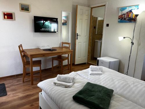 a room with a bed and a desk and a television at Pensiunea Andra in Jurilovca