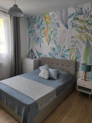 une chambre avec un lit avec un papier peint tropical dans l'établissement Charmant T3 climatisation parking alarme, à Toulon