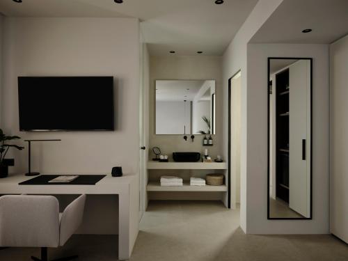 a white room with a desk and a television on the wall at Bond Smart Living Suites in Athens