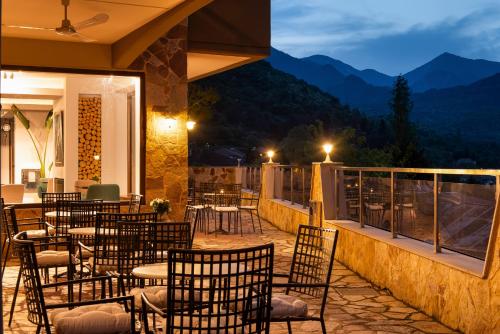 a restaurant with tables and chairs on a balcony at night at Hotel Naiades in Órma