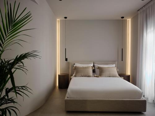 Un dormitorio con una cama blanca y una planta en Bond Smart Living Suites en Atenas
