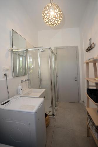 a bathroom with a sink and a shower and a mirror at Marco Polo 30 in Porto Recanati