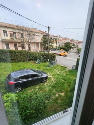 a black car parked in the grass outside a window at Seaside Apartment Bubi in Crikvenica