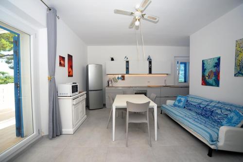 uma cozinha com uma mesa e uma cama num quarto em Marco Polo 30 em Porto Recanati