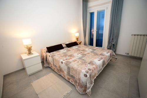 een slaapkamer met een bed en een nachtkastje met 2 lampen bij Marco Polo 30 in Porto Recanati
