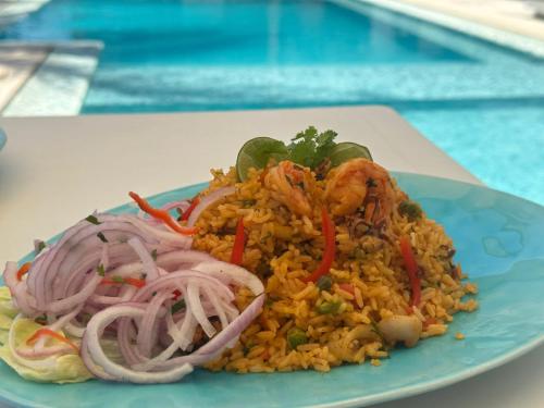 a plate of fried rice with shrimp and onions at Bungalows Playa Bonita in Máncora