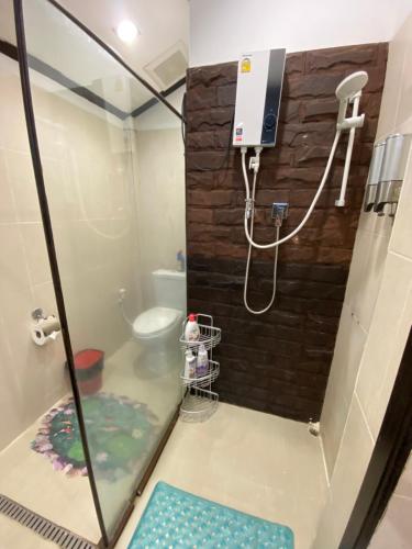 a shower in a bathroom with a glass door at Lris villas in Phuket Town