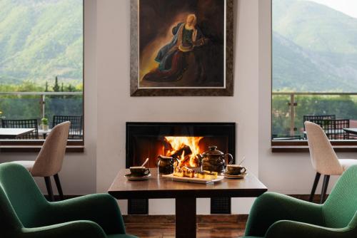 a fireplace in a living room with a table and chairs at Hotel Naiades in Órma