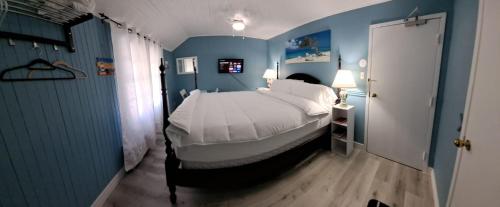 1 dormitorio con 1 cama grande en una habitación azul en Windspire Inn, en Port Elgin