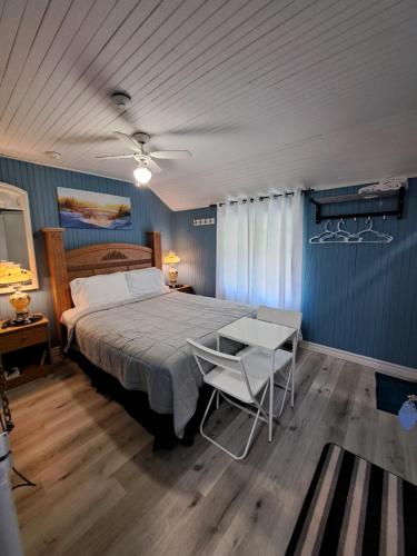a bedroom with a bed and a table with a chair at Windspire Inn in Port Elgin