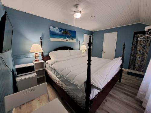 1 dormitorio con 1 cama grande y paredes azules en Windspire Inn, en Port Elgin