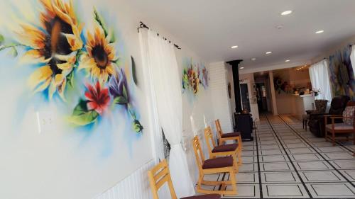 a room with a painting of sunflowers on the wall at Windspire Inn in Port Elgin