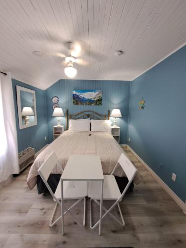 a bedroom with a large bed with blue walls at Windspire Inn in Port Elgin