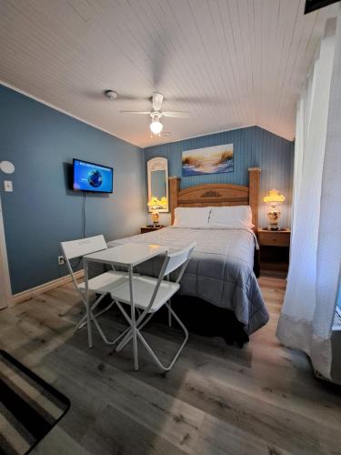 a bedroom with a bed and a table and a tv at Windspire Inn in Port Elgin