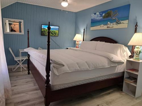 a bedroom with a bed and a table and a desk at Windspire Inn in Port Elgin