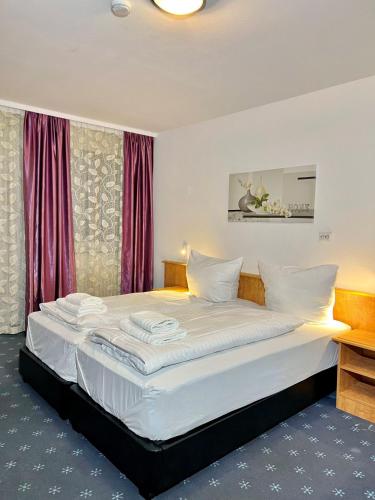 1 dormitorio con 1 cama blanca grande y cortinas rojas en Hotel Neo Cologne Bonn Airport, en Rösrath