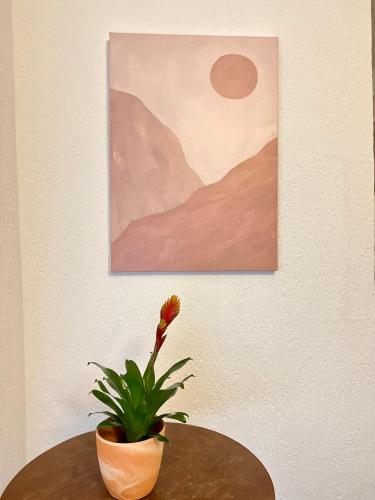 a plant sitting on a table next to a painting at Hotel Neo Cologne Bonn Airport in Rösrath