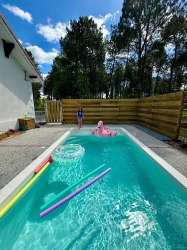 - une fille debout dans une piscine avec des pataugeoires et un flotteur dans l'établissement La Maison de Marie, à Saint-Julien-en-Born