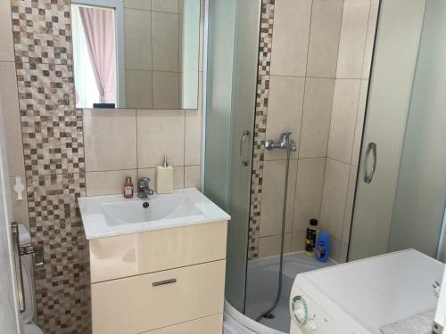 a bathroom with a sink and a shower at Plaža Stari Grad Budva pjena od mora Beach Apartman in Budva