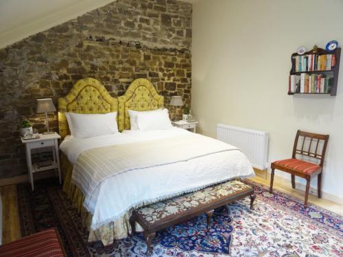 1 dormitorio con 1 cama grande y pared de ladrillo en Hollamoor Farm, en Barnstaple