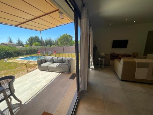 un salon avec un canapé et une terrasse dans l'établissement Villa en Provence, à Saint-Saturnin-lès-Apt