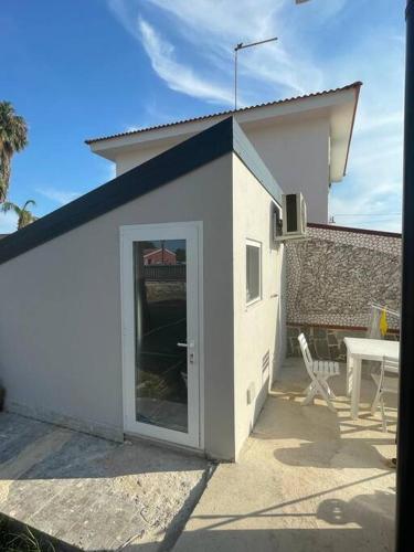 a small white building with a door and a table at Mini luxury suite Ortea in Siracusa