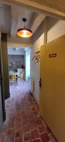 a hallway with a table and a yellow door at Logis La Vachère in Avallon