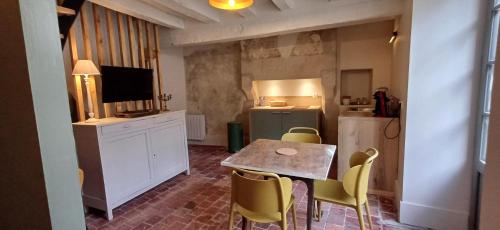 a kitchen with a table and chairs and a refrigerator at Logis La Vachère in Avallon