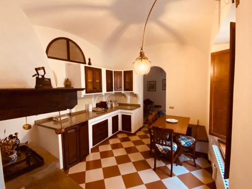 a kitchen with a checkered floor and a dining room at La sosta del viandante in Sinalunga