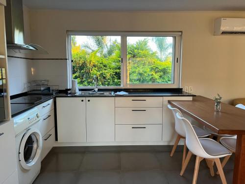 cocina con fregadero, mesa y ventana en Casa Country Altos Arrayanes, en Mercedes