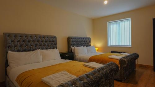 ein Hotelzimmer mit 2 Betten und einem Sofa in der Unterkunft THROSTLES NEST APARTMENTS in Manchester