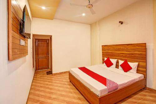 Banūr的住宿－Super OYO Hotel NR Residency，一间卧室配有红色枕头的床