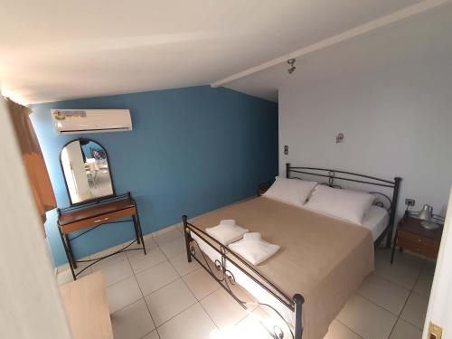 a small bedroom with a bed and a mirror at Karavados Beach Hotel in Karavadhos