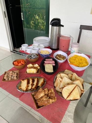 une table recouverte de beaucoup de différents types de nourriture dans l'établissement Casa de Vidro Sairé, à Récife