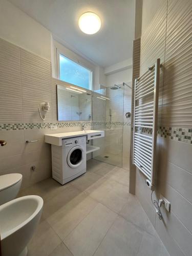 a bathroom with a sink and a washing machine at Le Ghiaie Relax in Portoferraio