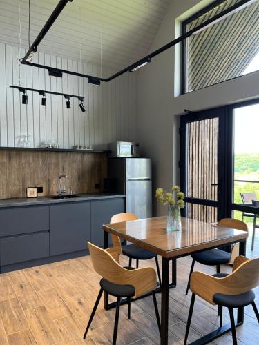 a kitchen and dining room with a table and chairs at Barnhouse "Family Estate" in Kamianets-Podilskyi
