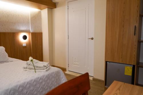 a bedroom with a bed with a flower on it at Grand Hotel Santa Ana in Cuenca