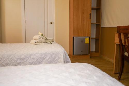 a room with two beds and a teddy bear at Grand Hotel Santa Ana in Cuenca
